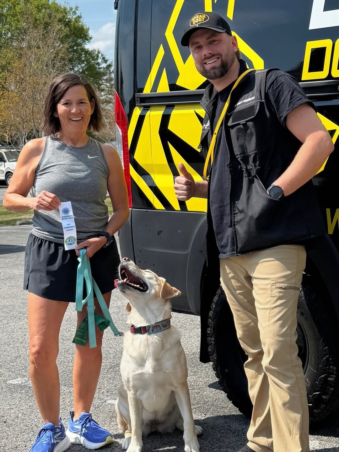 Garrett Fredricks with a client and her trained dog in front of the EZ-K9 van